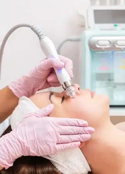 Frau erhält eine professionelle Gesichtsbehandlung mit einem speziellen Gerät bei Behnaz's Beauty Bar